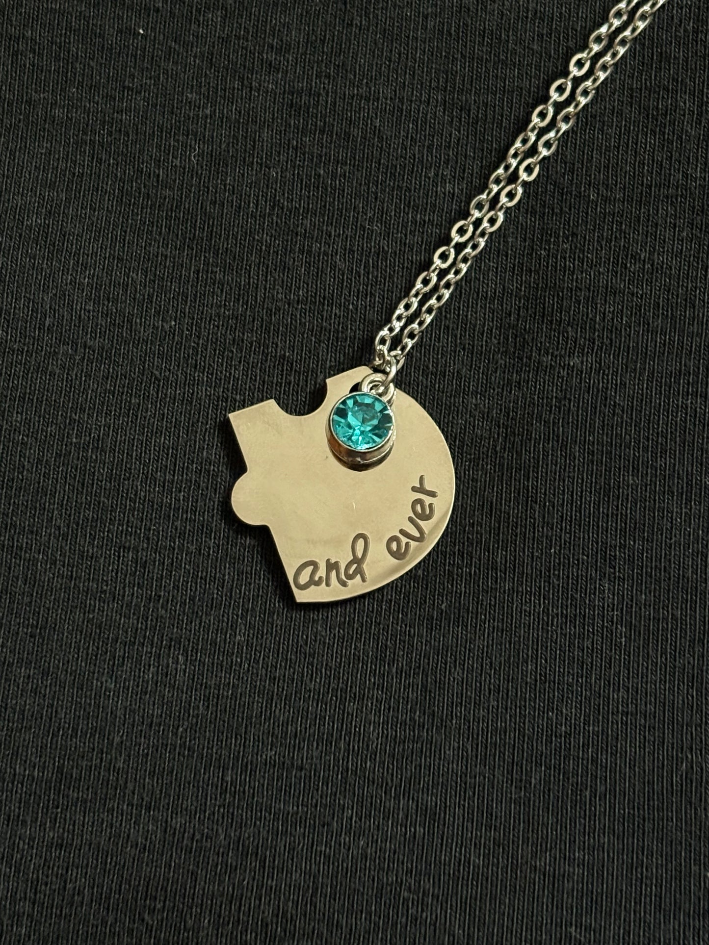 Necklace with a gold pendant shaped like a head with a blue gem on a black background