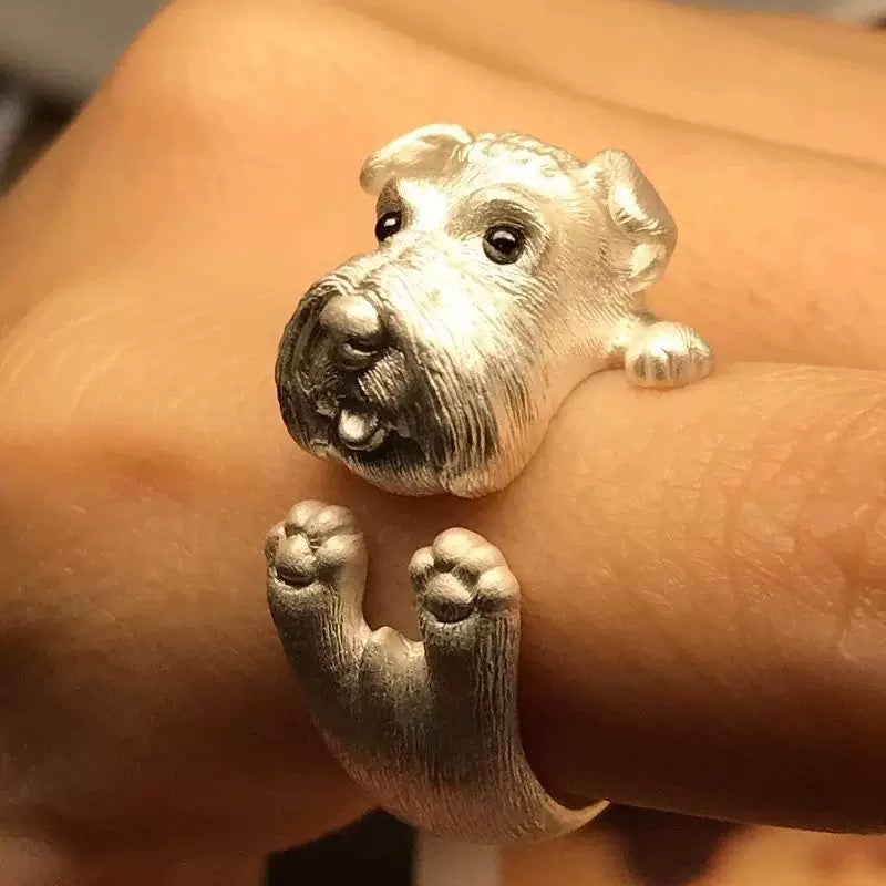 Silver dog-shaped ring on a person's finger