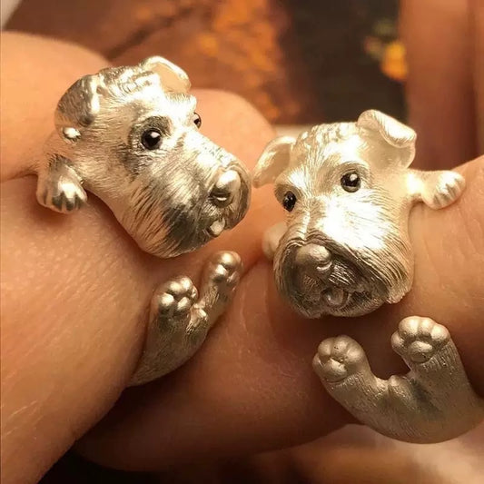 Silver dog-shaped rings on a person's finger