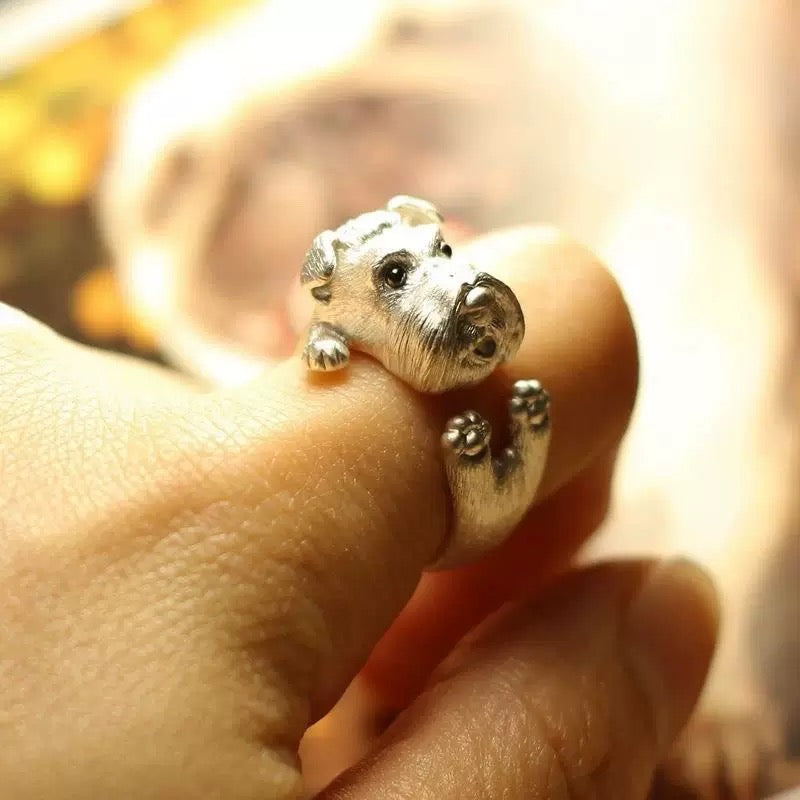 Silver bear-shaped ring on a finger with a blurred background