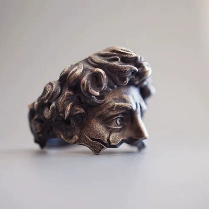 Bronze ring with detailed design on a light background